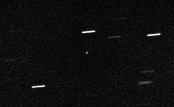 Enhanced telescope image of 'Oumuamua against a starfield